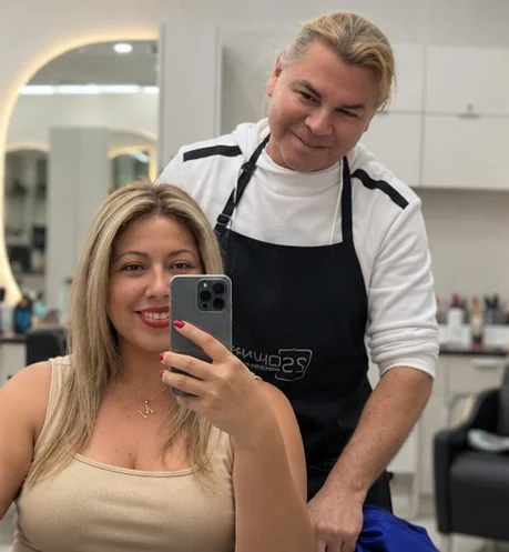 A client taking a mirror selfie with George behind her