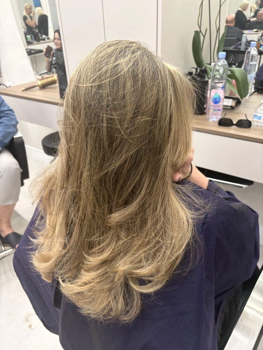 Soft blonde layers seen from behind, finished in the salon