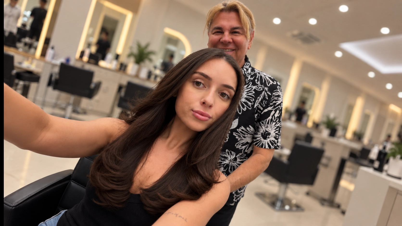 George Ivan Pena with a client and her long, glossy brunette hair in the salon